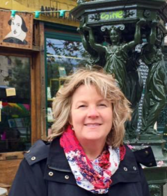 Mrs. Kong standing in front of Shakespeare and Company in Paris and a green fountain